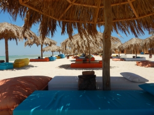 Sunbeds on the sandy beach of Tobia Island in front of the turquoise blue sea