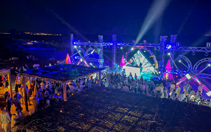 A vibrant Full Moon Party at KiteHouse Somabay, featuring live DJ music, colorful lights, and an energetic beach crowd under the night sky.